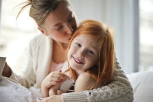 mum kissing daughter