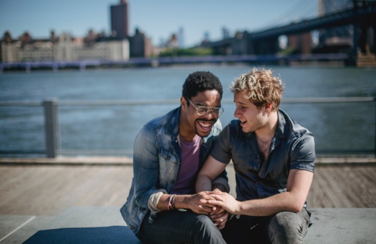 Two men laughing and holding hands