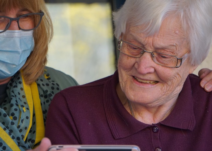 An elderly lady looking at a phone