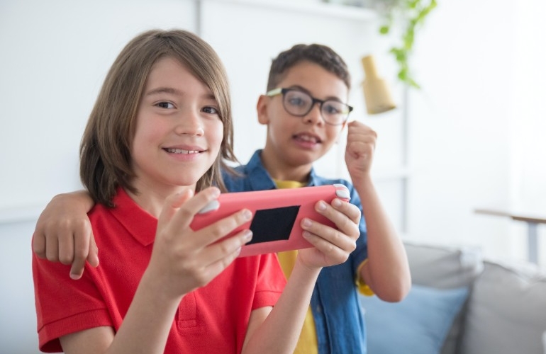 Happy Children with hand held computer game