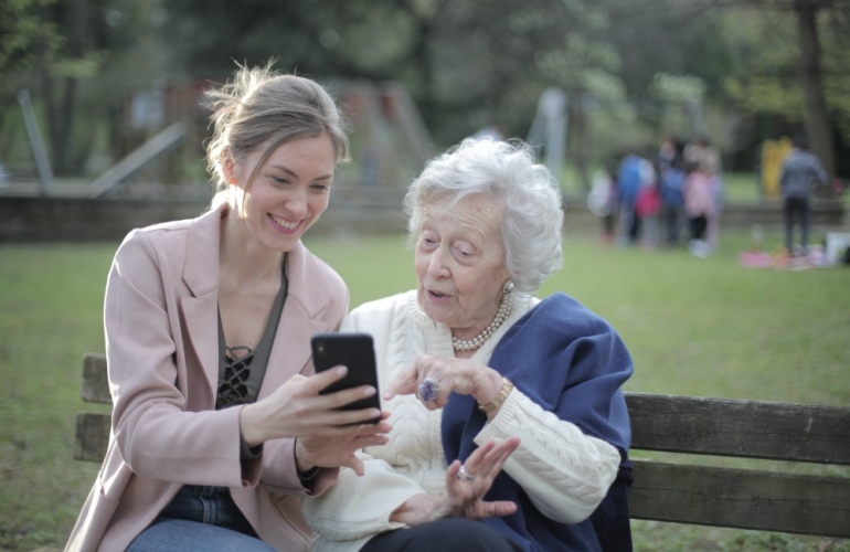 Woman showing older woman her phone