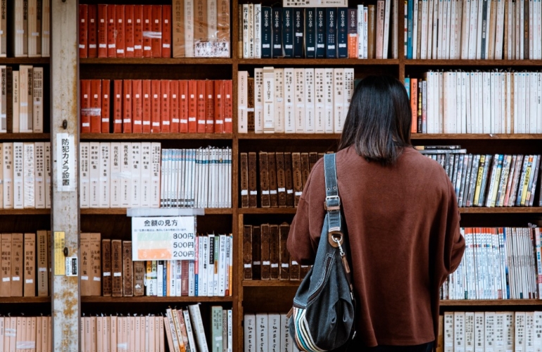 Girl looking at a shelf of books