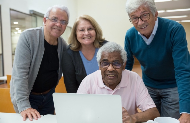 A group of people gathered around a laptop