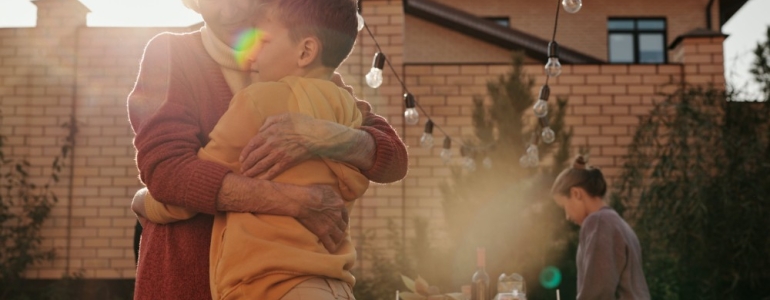 A grandmother hugging her grandson