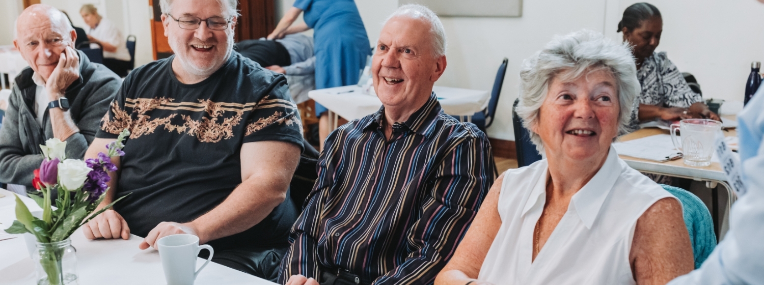 4 people sitting at a table smiling